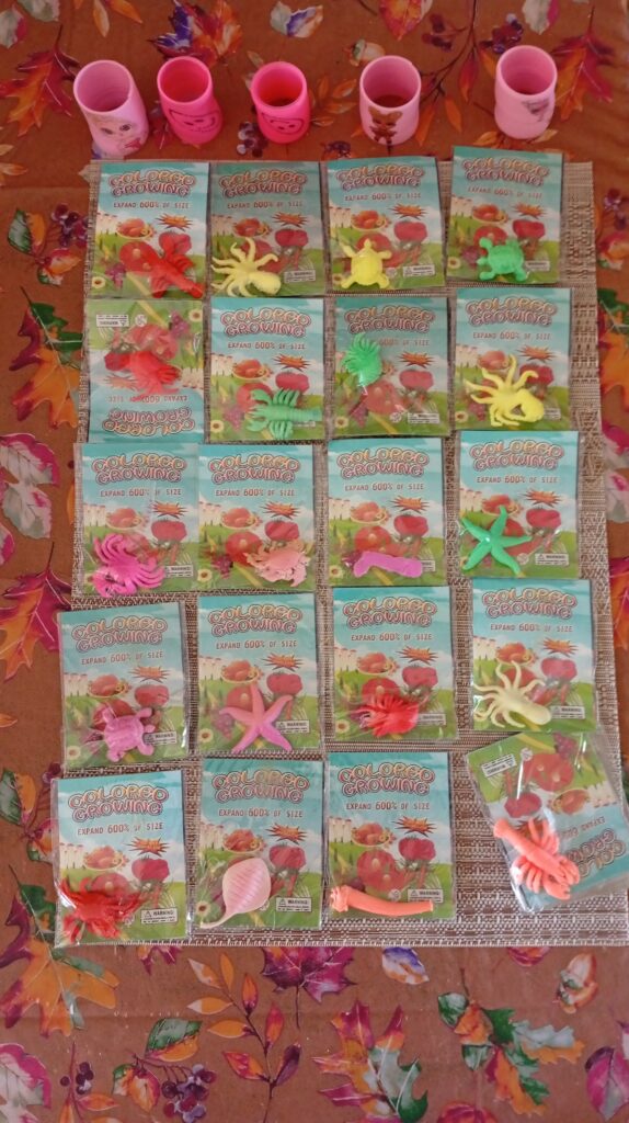 Bundle of ~25 Sealed ‘Colored Growing’ Expand-in-Water Novelty Toys + 5 Pink Cups