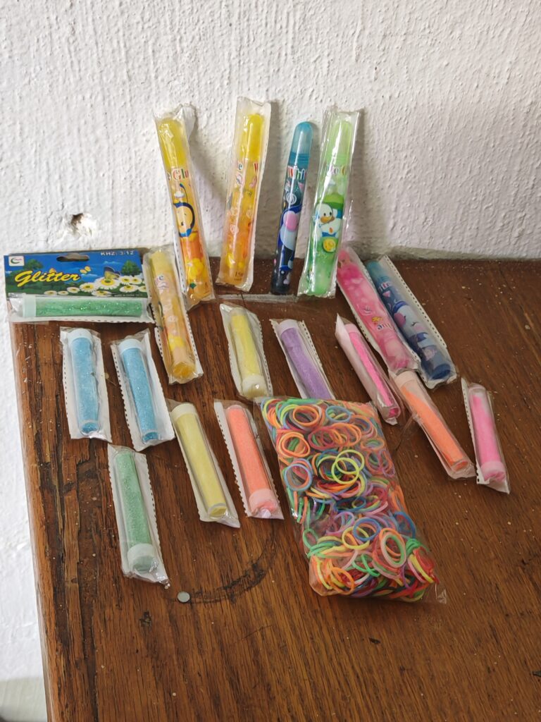 Mixed lot: approx. 17–19 sealed craft glitter/gel tubes + small glitter box & elastic bands