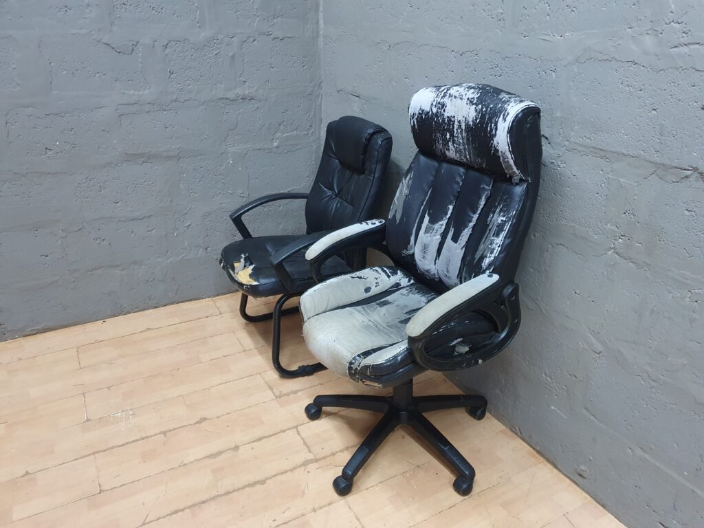 Pair of office chairs — high-back swivel + guest cantilever (damaged upholstery)