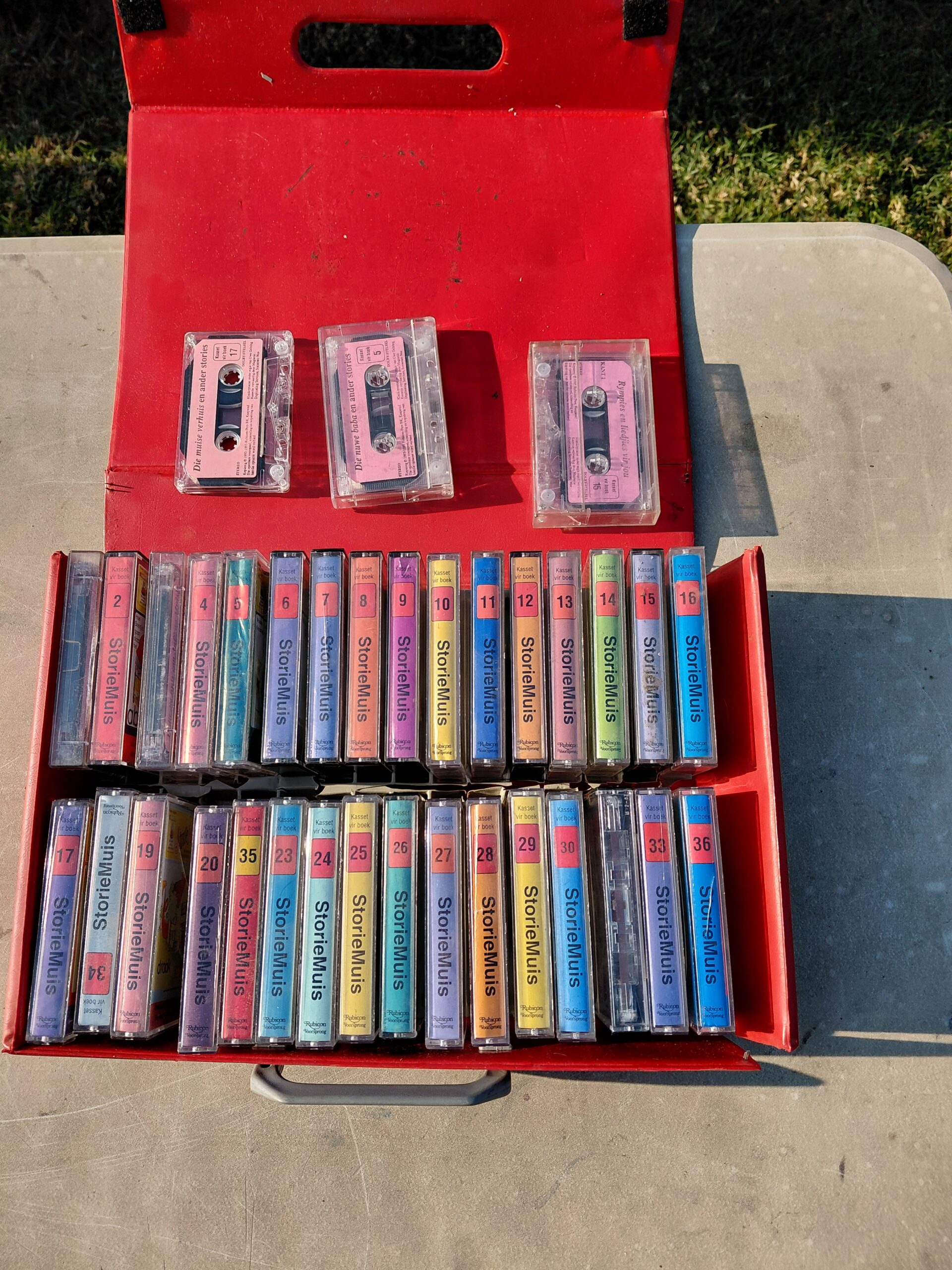 Collection of StorieMuis Afrikaans cassette story tapes in red carrying case
