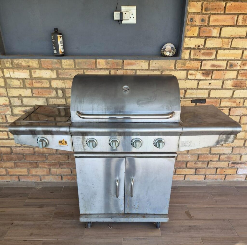 Stainless-steel 4-burner LPG gas braai with side burner and rotisserie spit (working, needs clean)