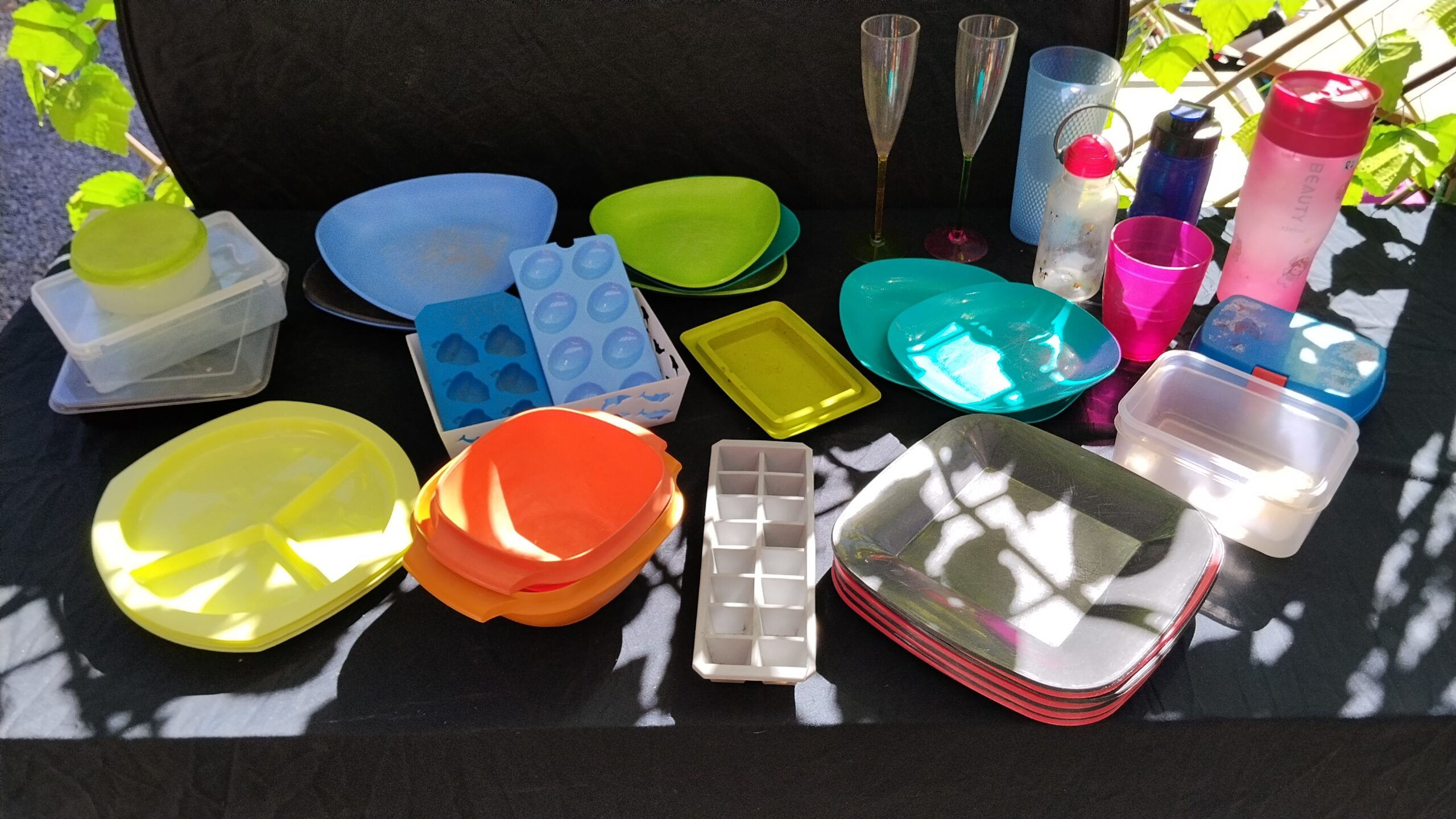 Mixed lot of ~25–30 plastic plates, containers, bottles and cups