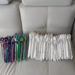 Bulk lot of mixed clothes hangers — predominantly white, assorted colours