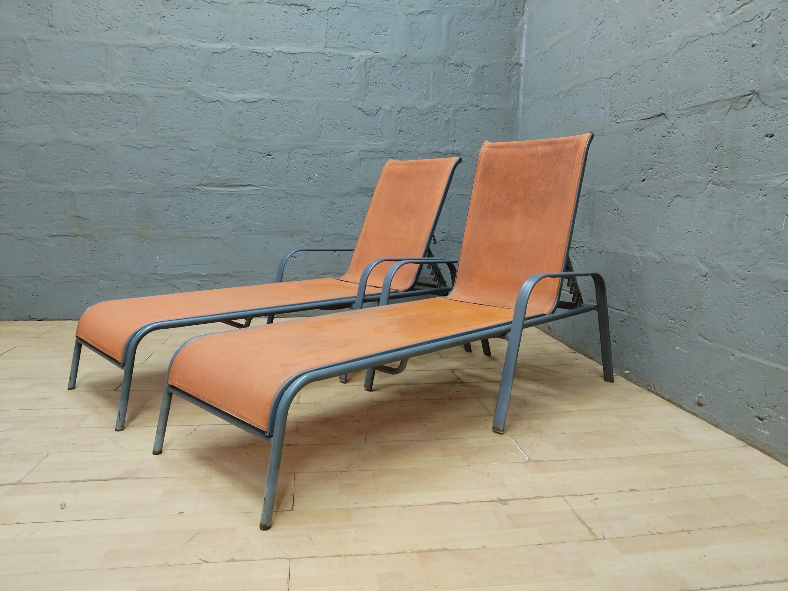 Pair of Orange Sling Outdoor Sun Loungers with Grey Tubular Frames