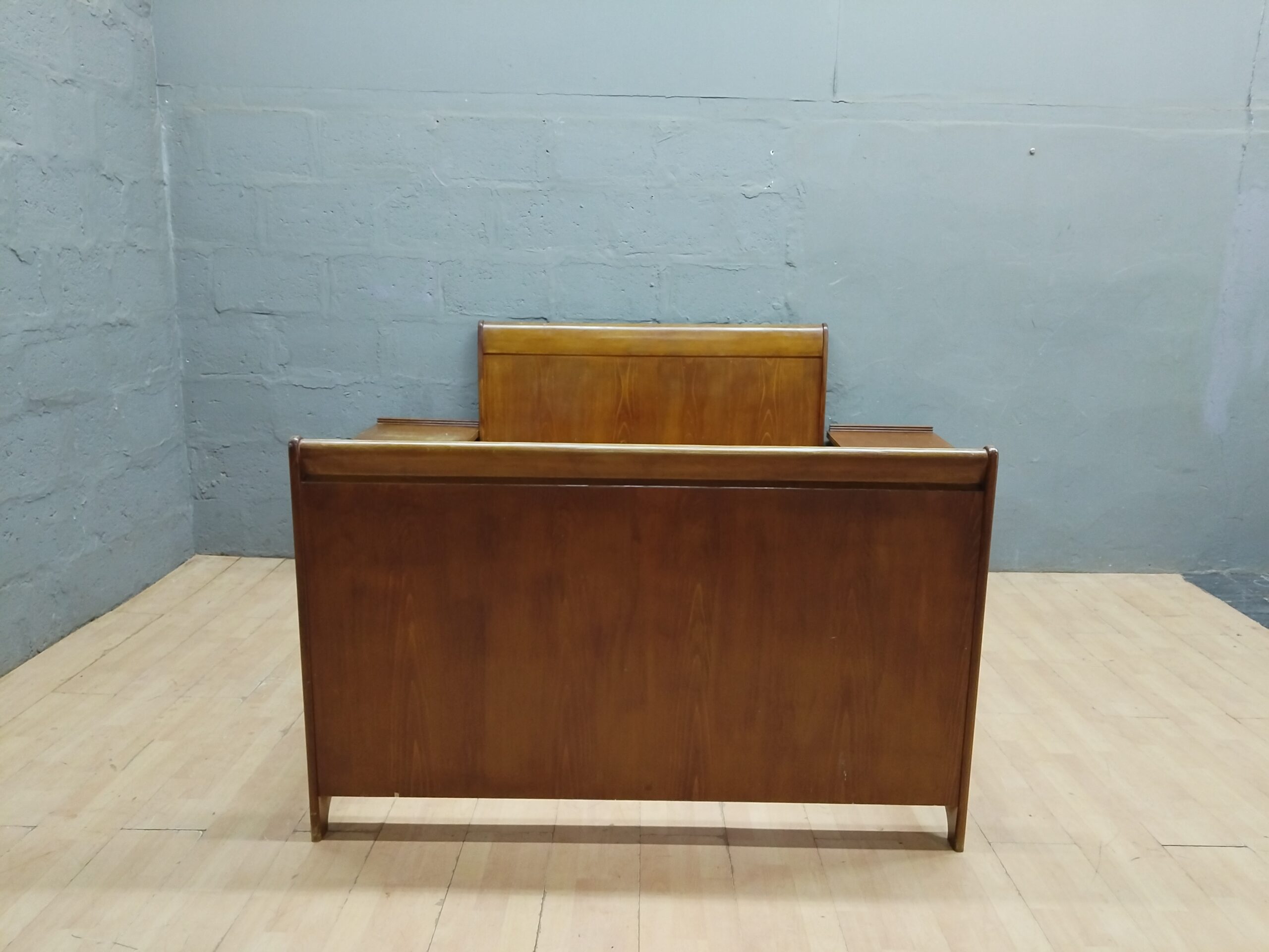 Double bed frame with two matching nightstands, wood-tone finish, visible surface wear