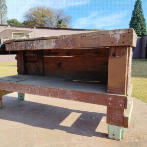 Large used wooden workbench with attached metal vise