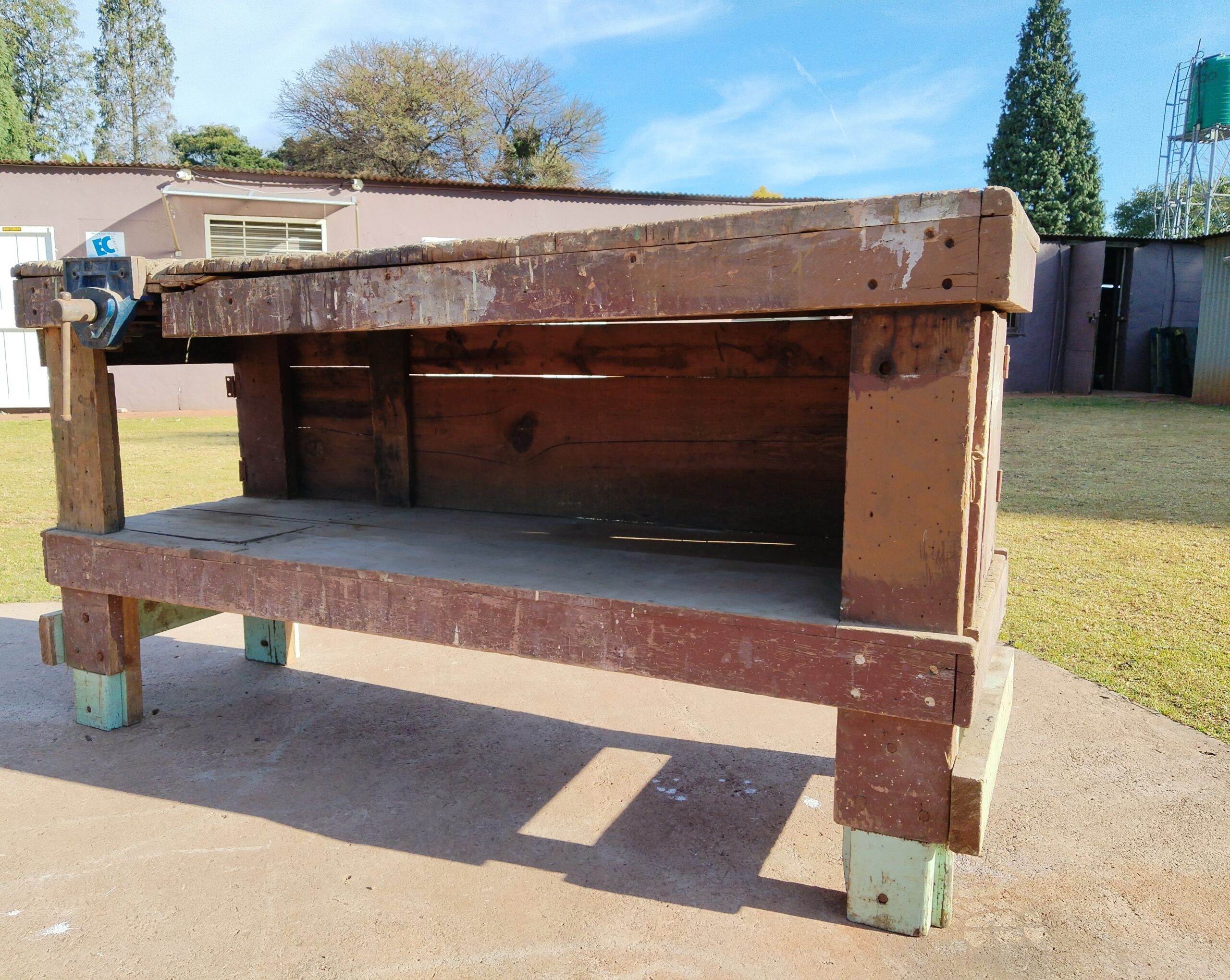 Large used wooden workbench with attached metal vise