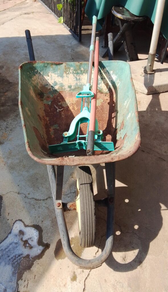Rusty Single-Wheel Metal Wheelbarrow — Solid Frame, Tub with Surface Rust, Wheel Holds Air