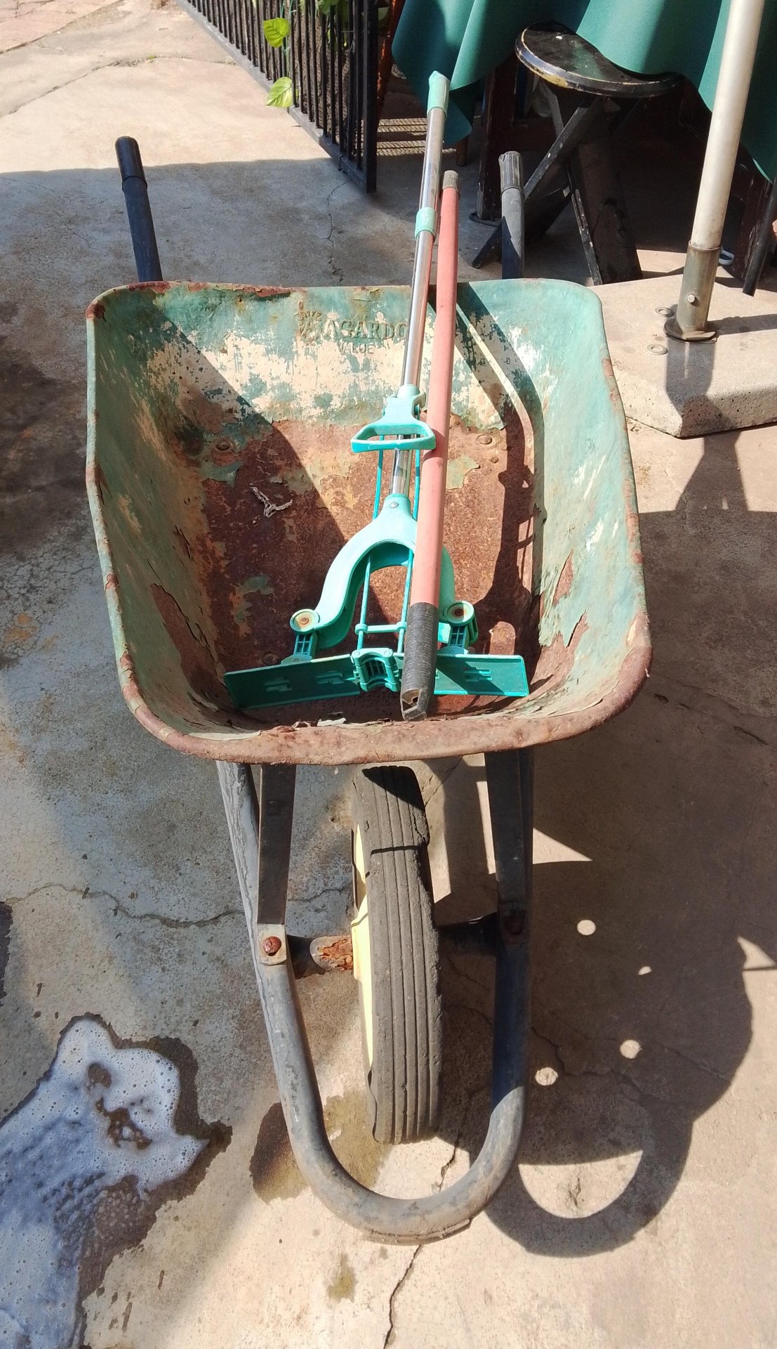 Rusty Single-Wheel Metal Wheelbarrow — Solid Frame, Tub with Surface Rust, Wheel Holds Air