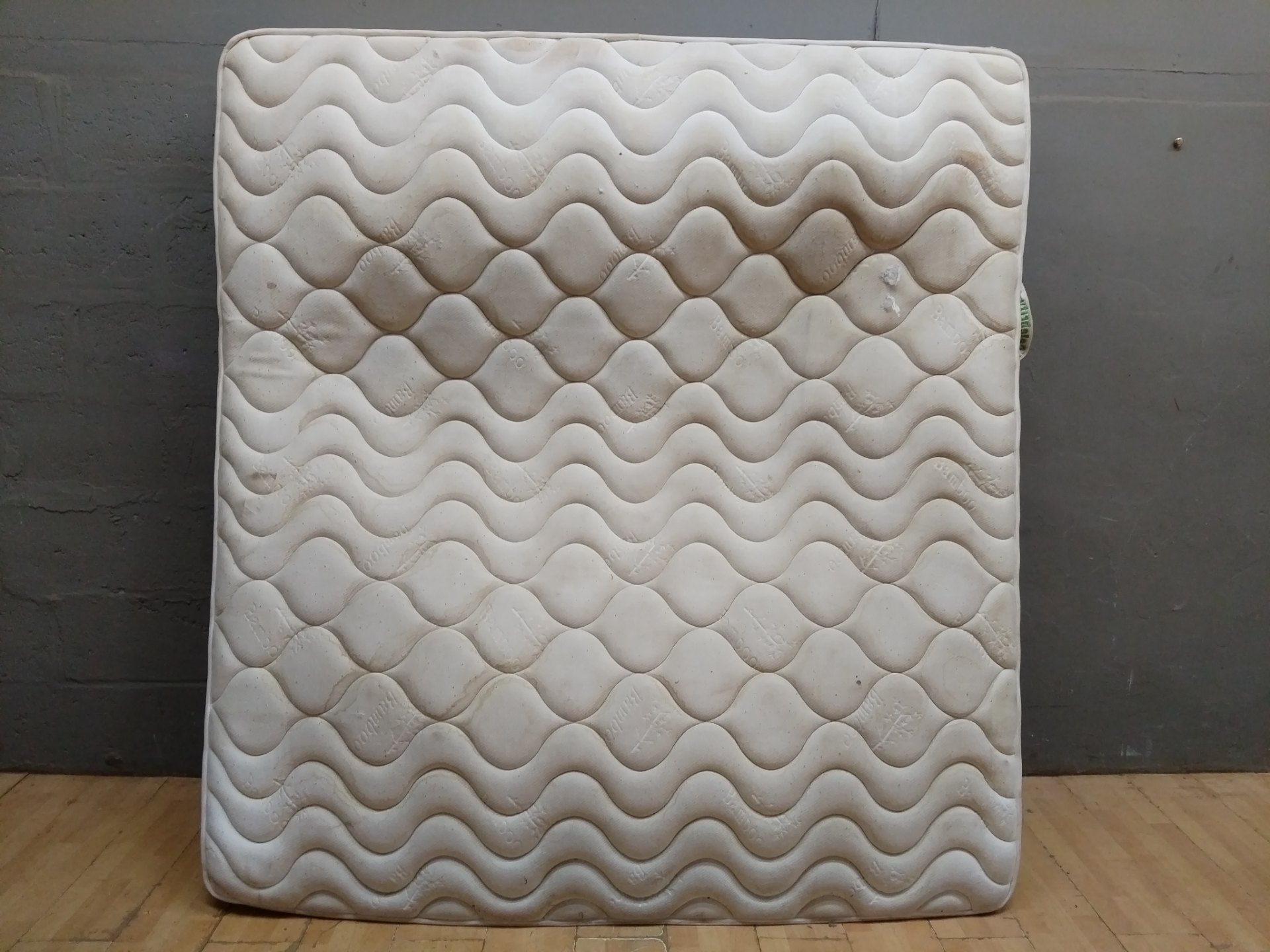 King-size pocketed coil mattress (labelled ‘Pocketed Coil Collection’) — heavily soiled, torn corner, salvage condition