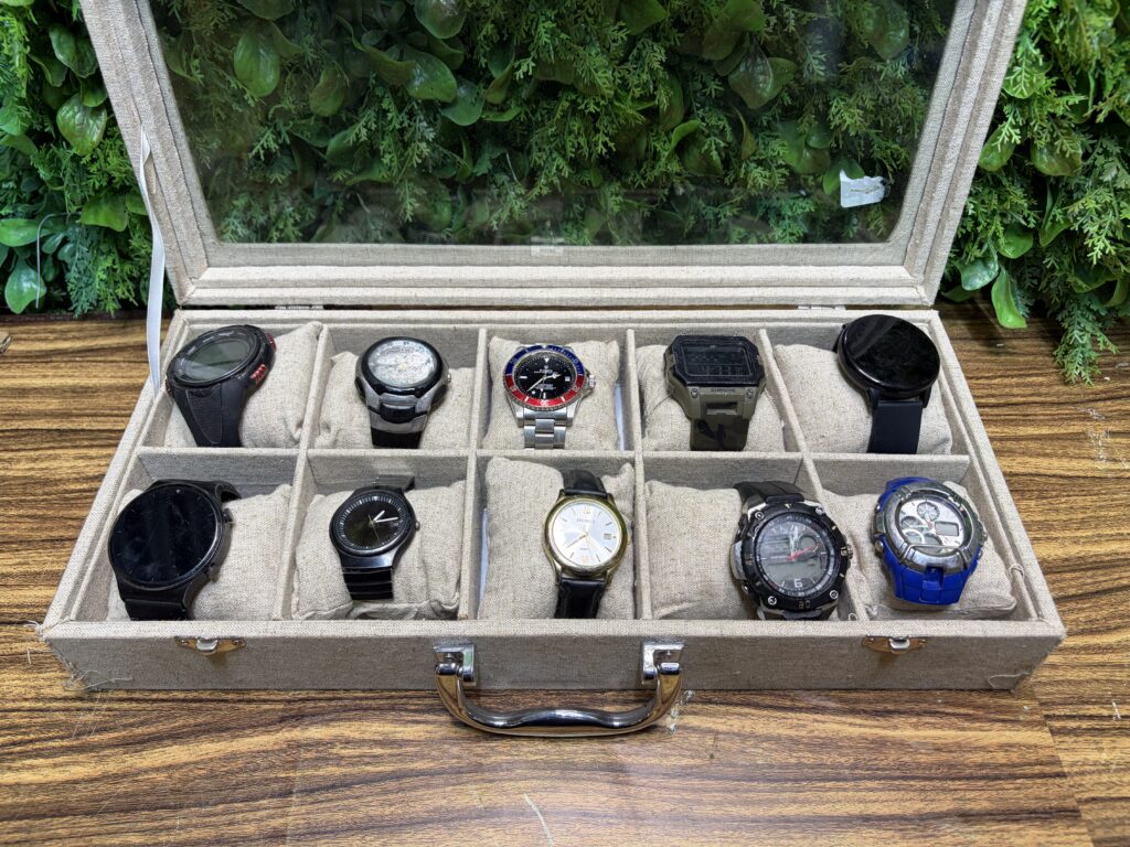 Lot of 10 Wristwatches in Glass-Top Display Case — Mixed Condition