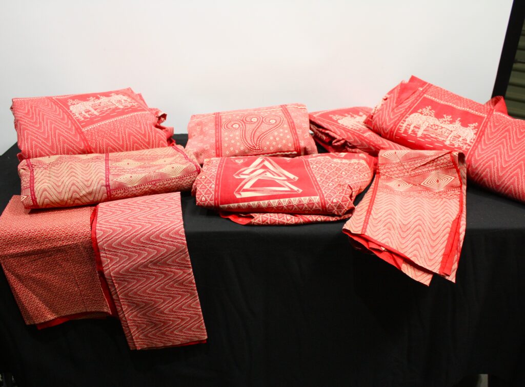 Lot of red printed African-style fabric — approx. 8 folded pieces