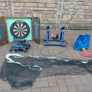 Mixed sports lot — Cyclo-trainer (motorised, worked last time), dartboard cabinet, RollerBall skates, net & paddles