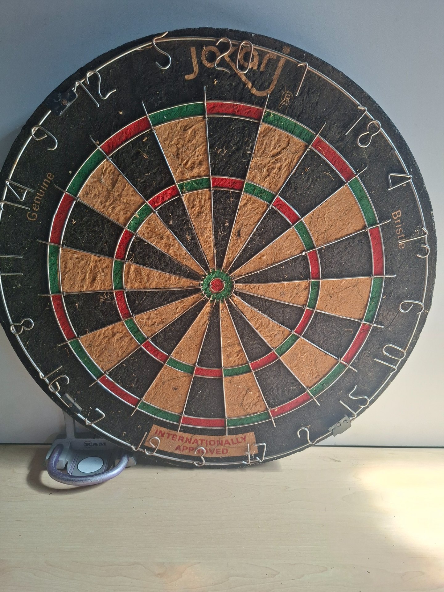 Used Bristle (sisal) dartboard — heavy wear, bent wires, hanger attached — board only
