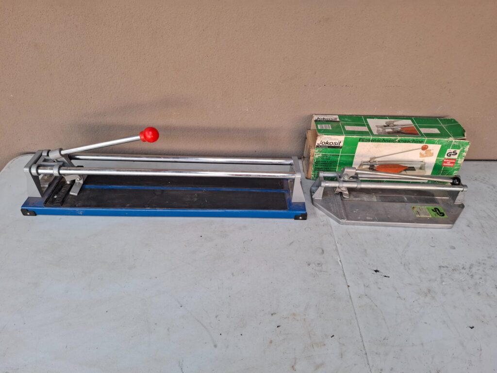Lot: Two manual tile cutters (long blue cutter + Jokosit boxed cutter) — used, untested