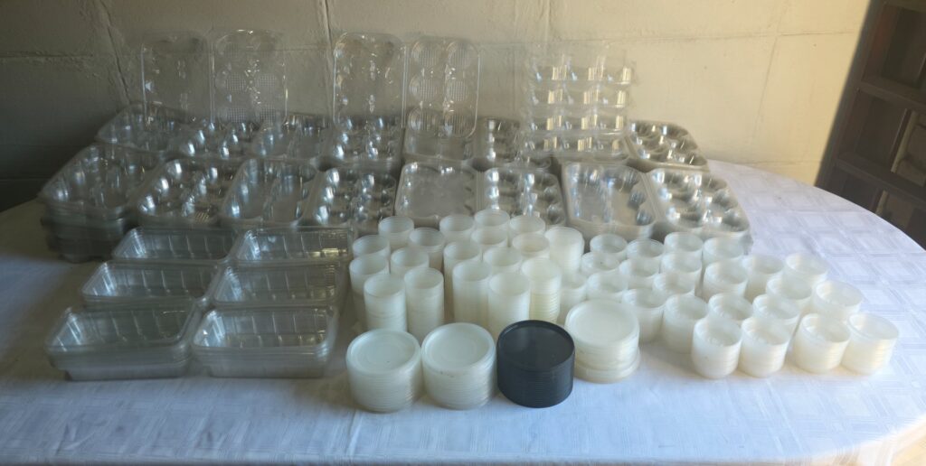 Bulk lot — approx. 1,450 clear plastic food trays & round lids, mixed/loose, new-or-like-new condition