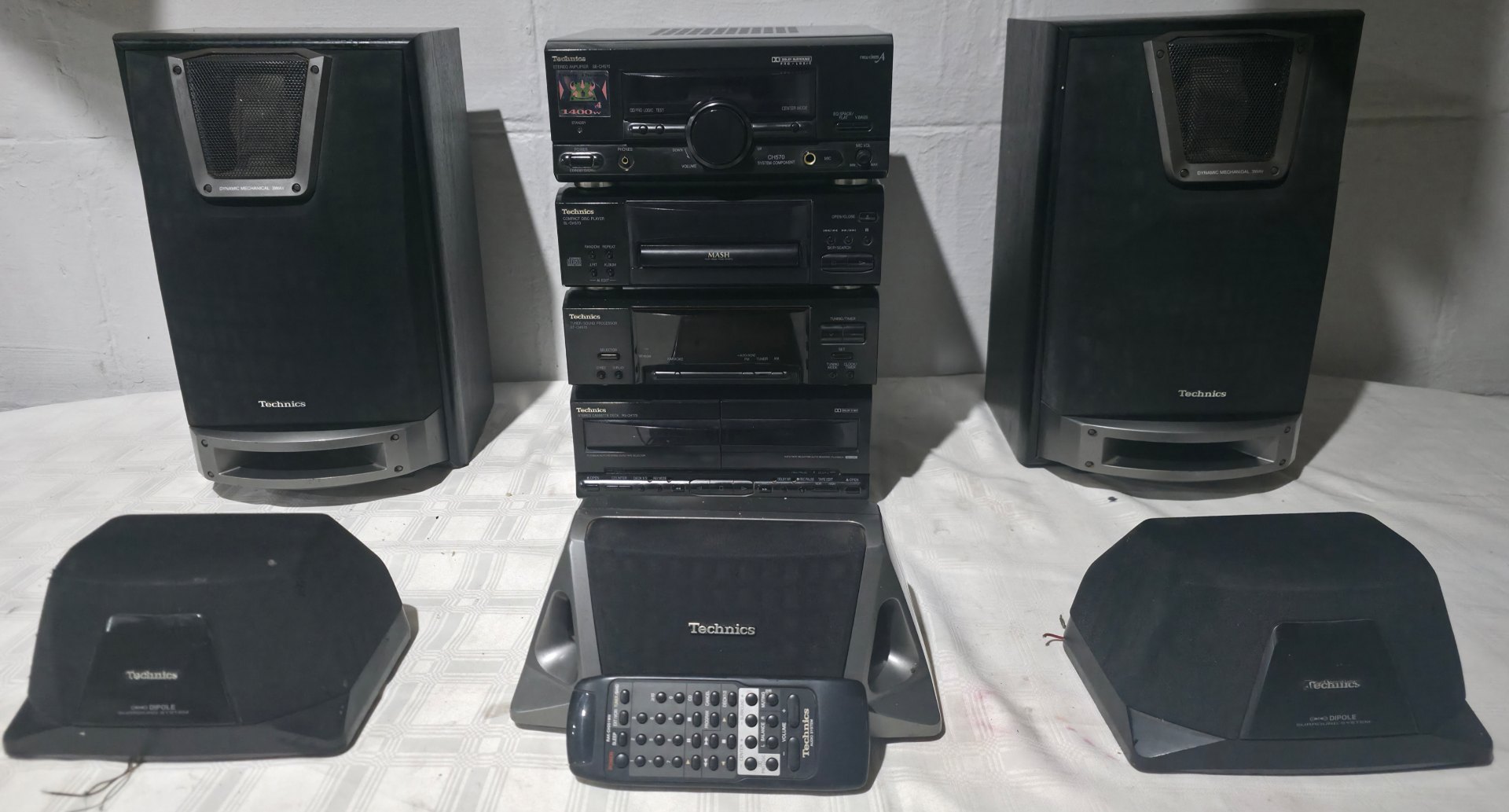Technics stacked mini hi‑fi system with five speakers and remote — powers on but no volume