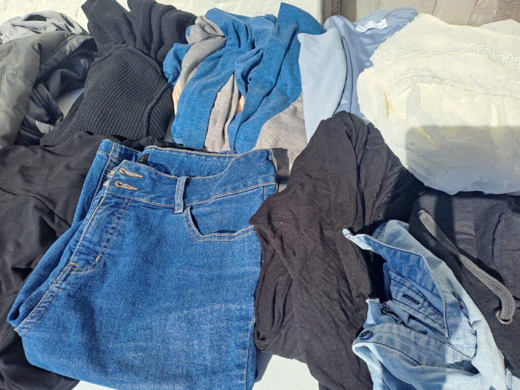 Mixed women’s clothing lot — jeans, knitwear, padded jacket & tops (used, visible wear)