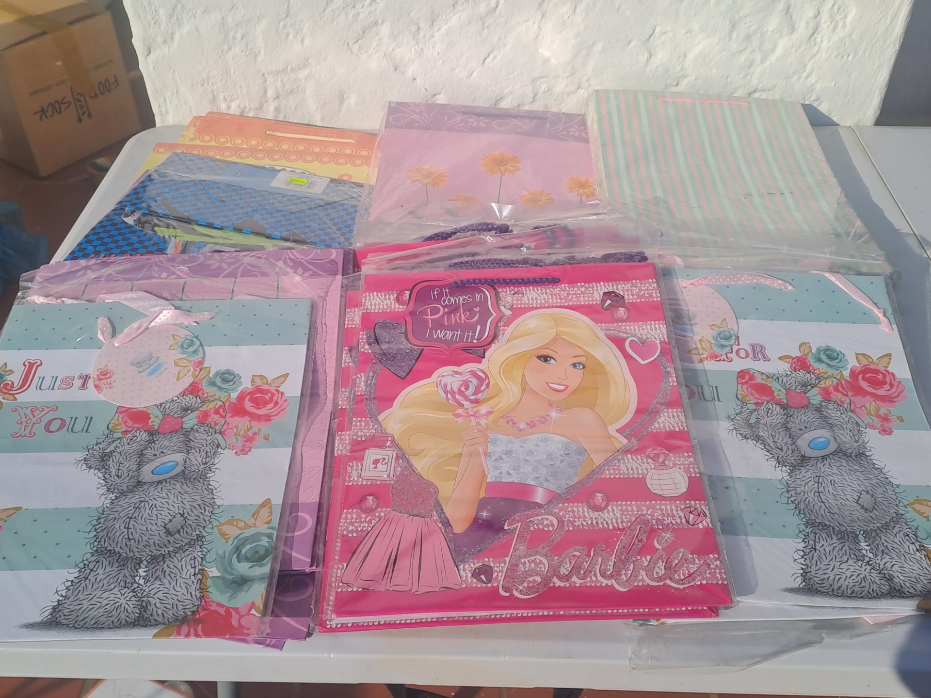 Bulk lot — approx 50 mixed-design paper gift bags (90% in packs) — kids, floral & striped styles