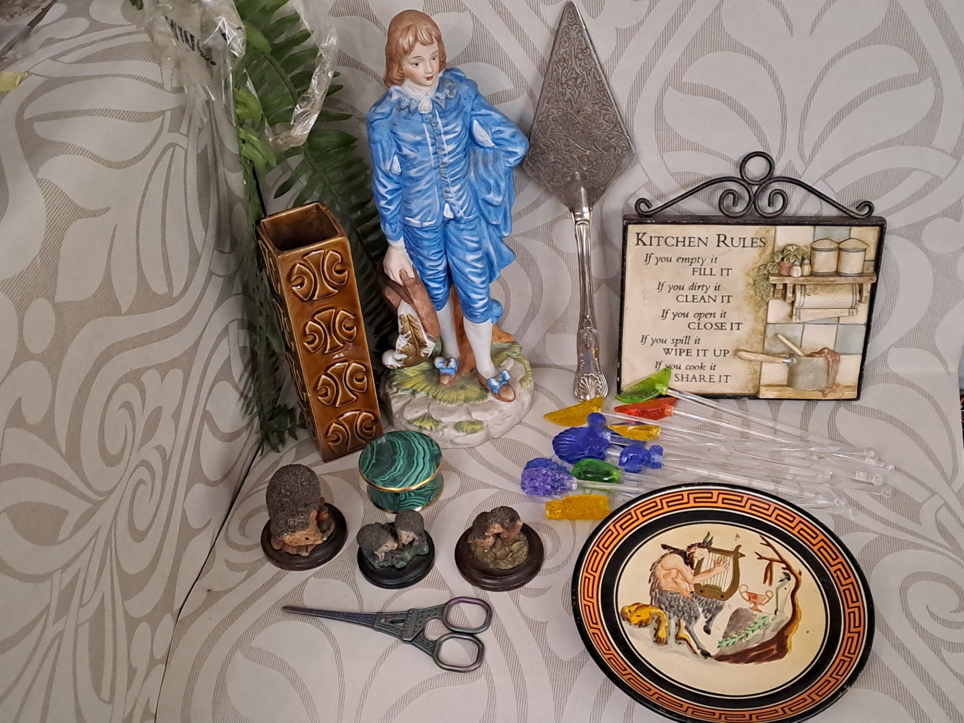 Mixed decorative lot — blue porcelain figure, Greek decorative plate, ornate silverplate server, malachite-style trinket box, hedgehog figurines & cocktail picks