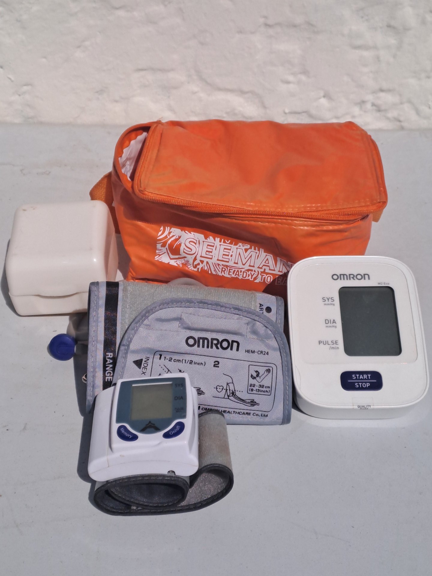 Mixed Omron blood pressure monitors (arm M2 Eco + wrist) with HEM-CR24 cuff, bag — working (needs batteries)