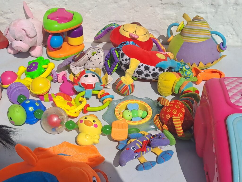 Assorted baby/toddler toys and plush lot — mixed rattles, soft toys & play cases (used)