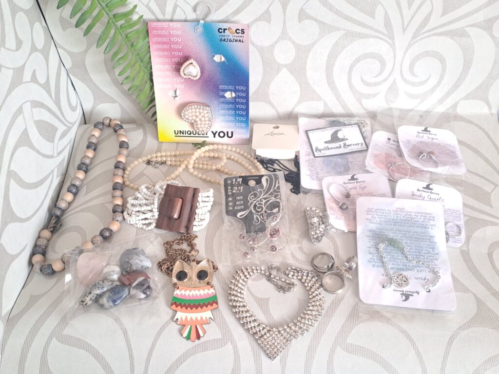 Mixed costume jewellery lot — necklaces, bracelets, rings, pendants, carded Crocs Jibbitz & Spellbound Sorcery crystal pieces