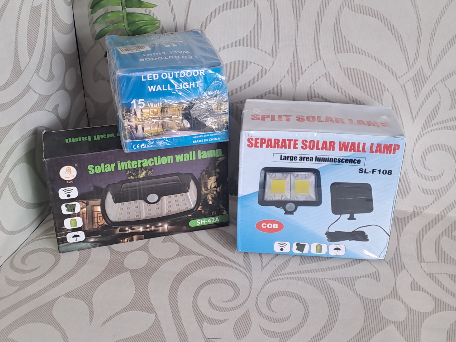 Assorted boxed solar LED wall lights — SL-F108, SH-42A & 15W LED (sealed boxes, untested, packaging scuffed)