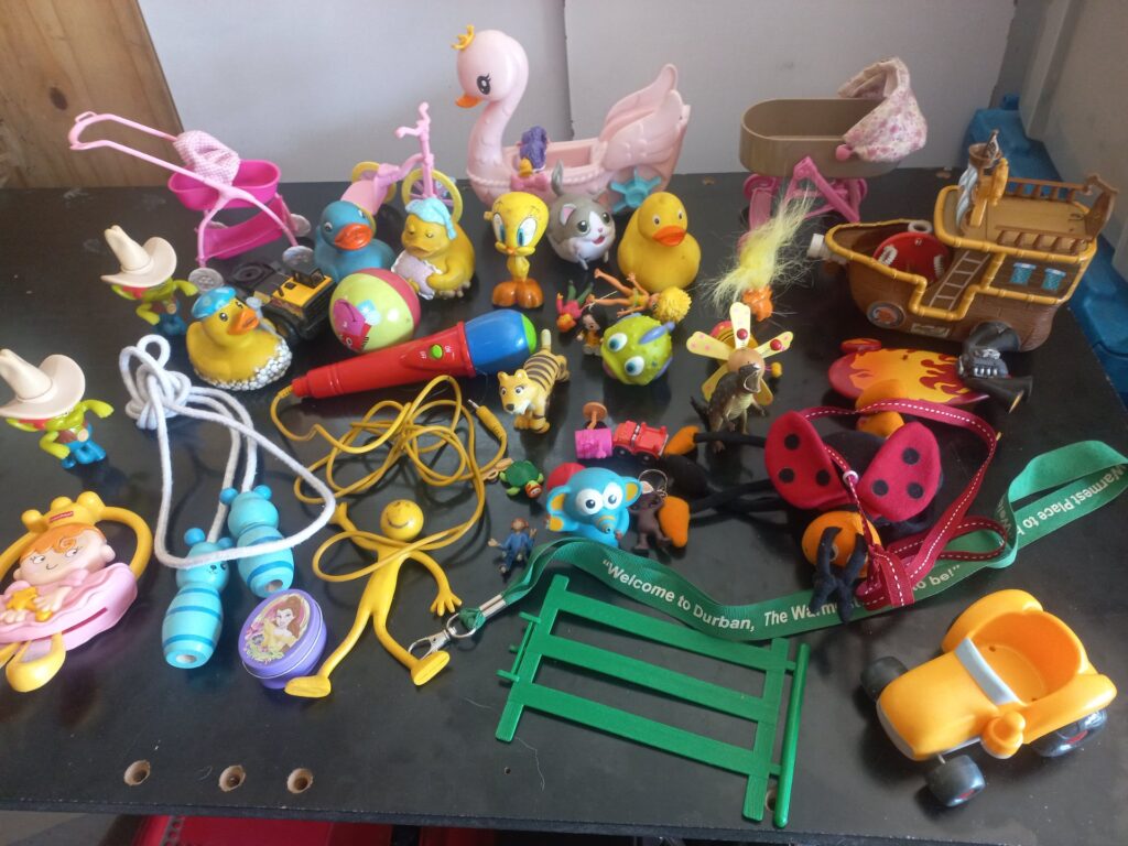 Mixed lot ~35 used children’s toys — ducks, prams, pirate ship, red corded microphone (untested)