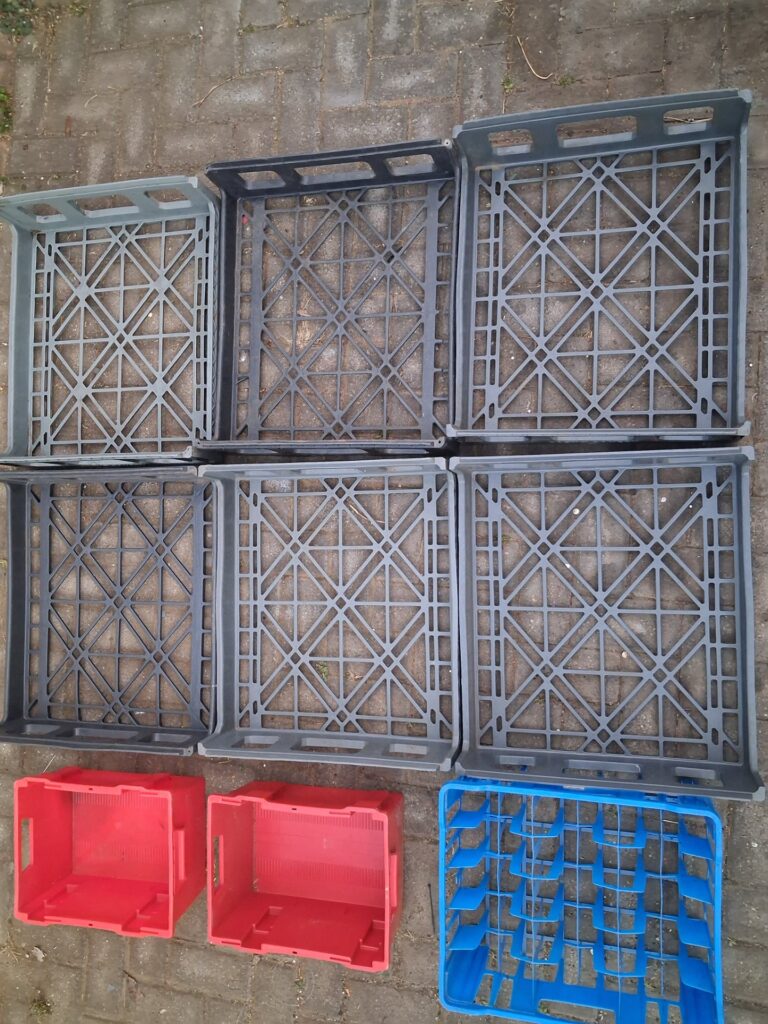 Lot of 9 Assorted Plastic Crates — 6 grey flat stacking trays, 2 red deep crates, 1 blue divider crate