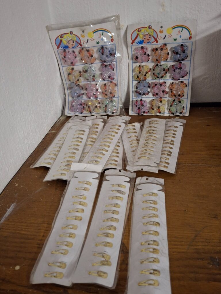 Mixed lot of children’s hair clips — gold-tone snap clips + sealed cartoon character plastic clips (original cards, aged packaging)