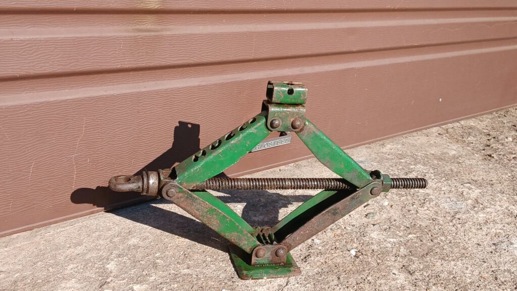 Green scissor-style car jack — manual, surface rust, untested (no long handle)