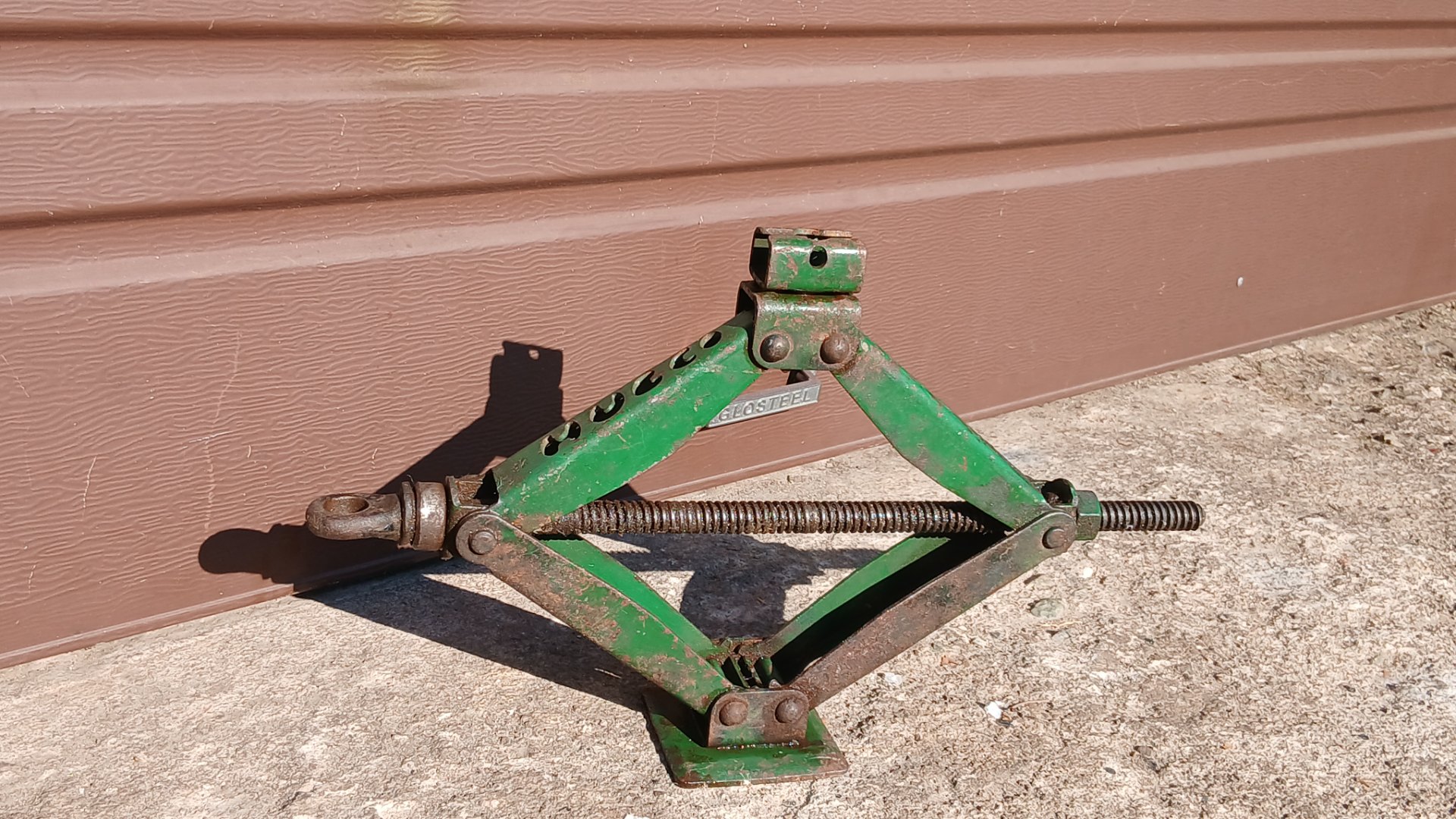 Green scissor-style car jack — manual, surface rust, untested (no long handle)