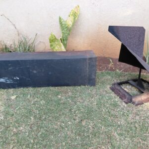 Abstract welded mild-steel garden sculpture with separate rectangular metal box (chimney flue/cowl) — heavy surface rust