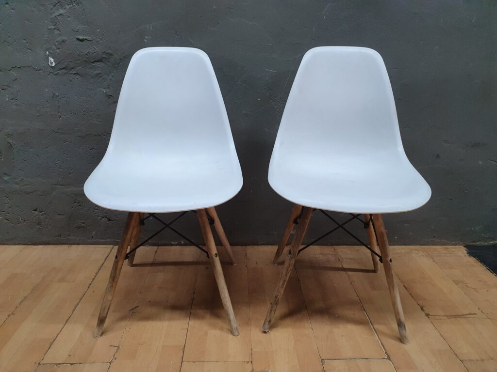Pair of white plastic shell chairs with wooden legs — used, needs clean