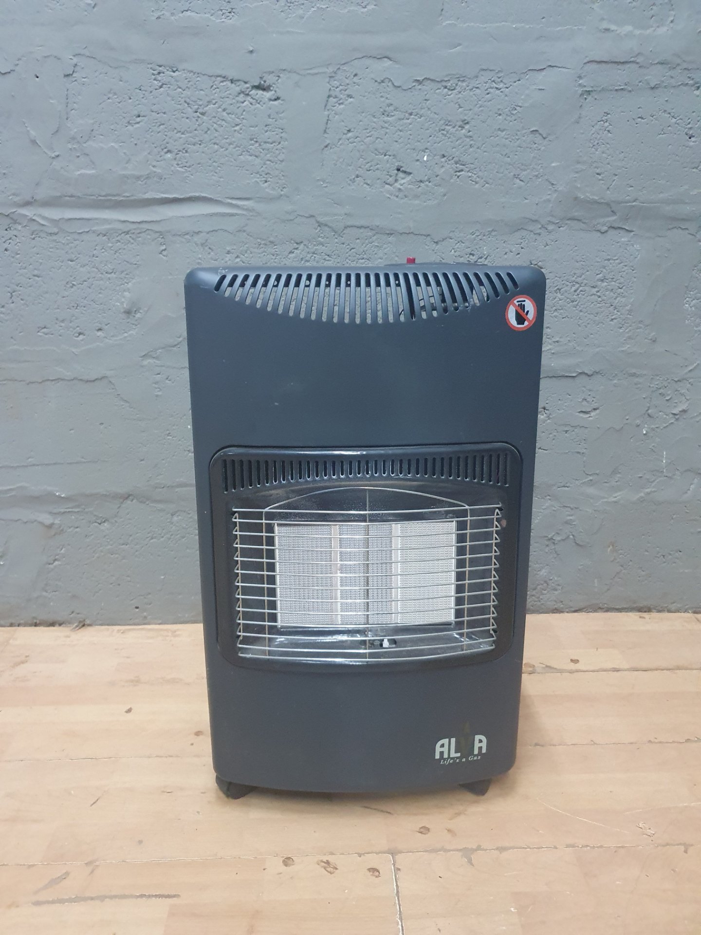 AL A portable floor gas heater — ceramic burner, grille, hose & regulator included (no cylinder)