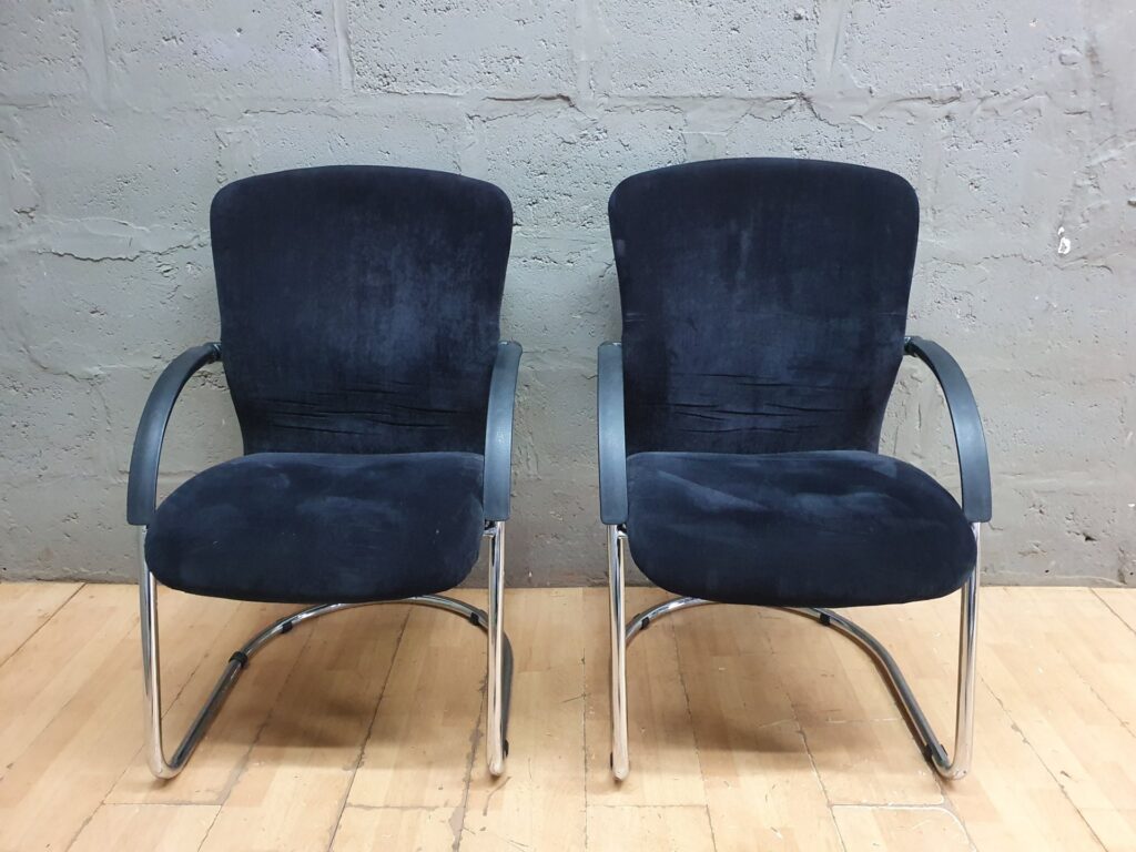 Pair of cantilever visitor chairs — navy/black upholstered seats, chrome sled bases