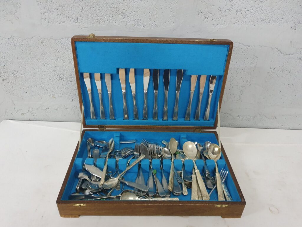 Assorted silver‑plated cutlery in wooden presentation box — mixed patterns, approx. 35 pieces, used