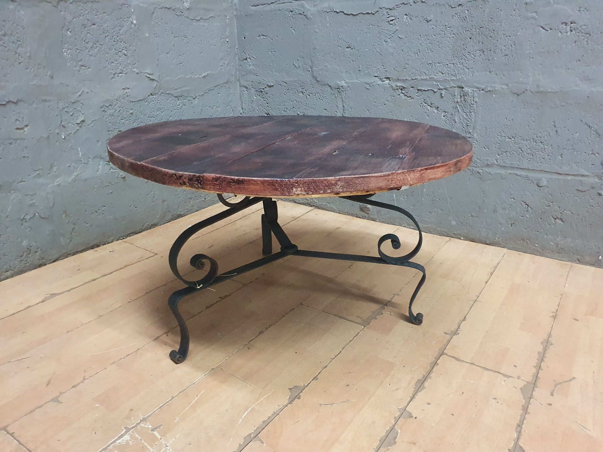 Round wooden coffee table with wrought-iron scroll base — D 82 x H 46 cm