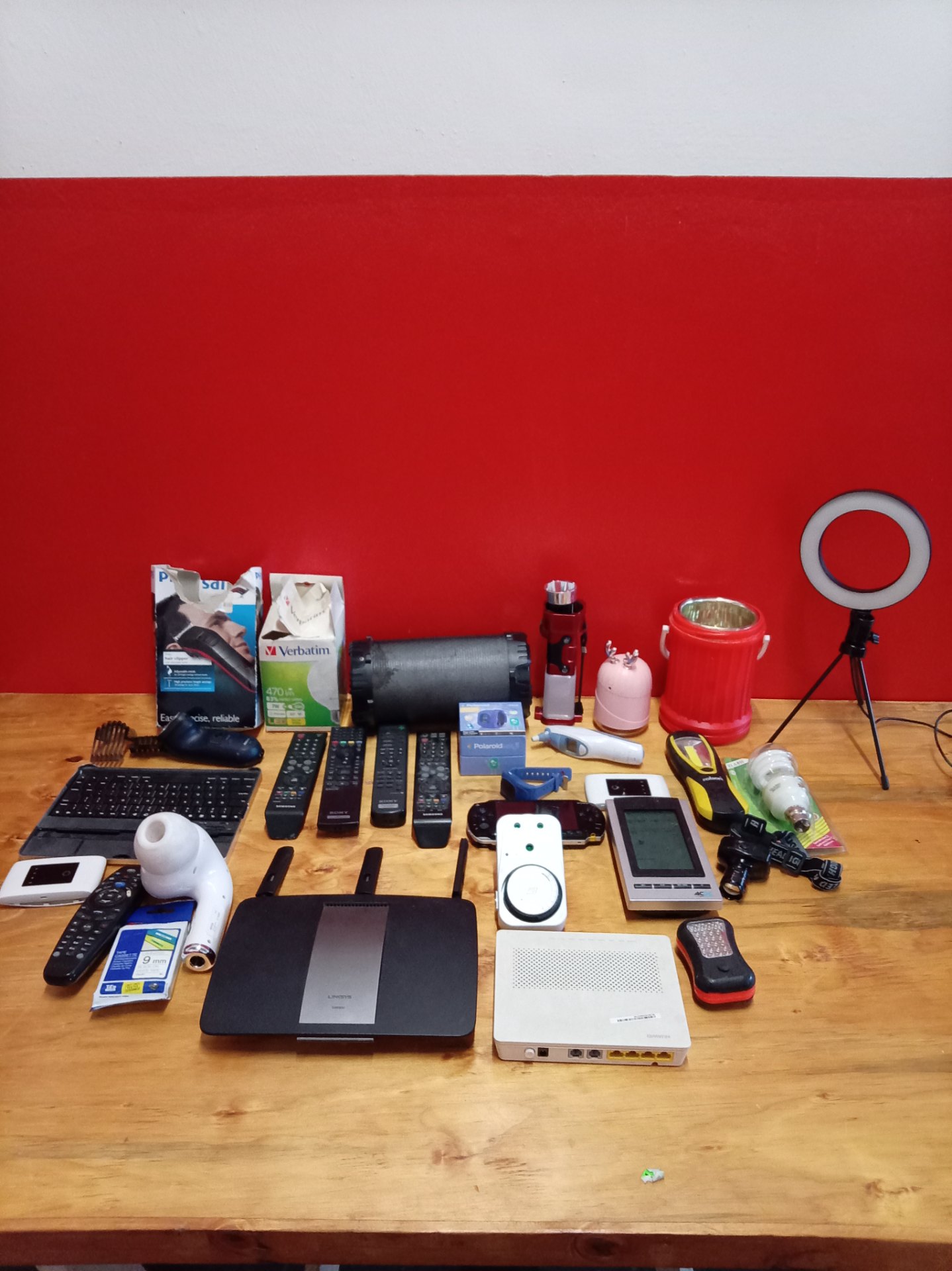 Mixed lot of small electronics & accessories — Linksys EA6900 router, Sony PSP-1000 (corroded), remotes, Polaroid Moji + more (Untested)
