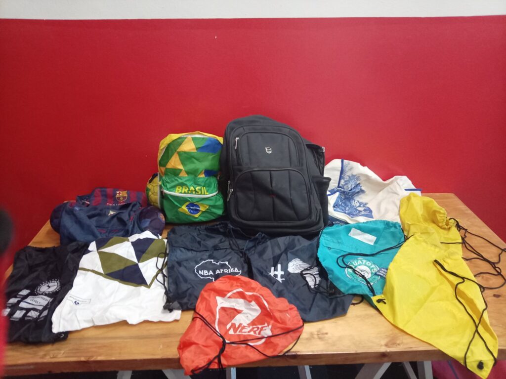Mixed lot of drawstring gym sacks (est. 8–10) plus black zip backpack — logos visible (Nerf, NBA, Brasil, FCB); used, some zips need repair