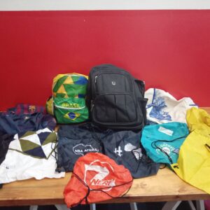 Mixed lot of drawstring gym sacks (est. 8–10) plus black zip backpack — logos visible (Nerf, NBA, Brasil, FCB); used, some zips need repair