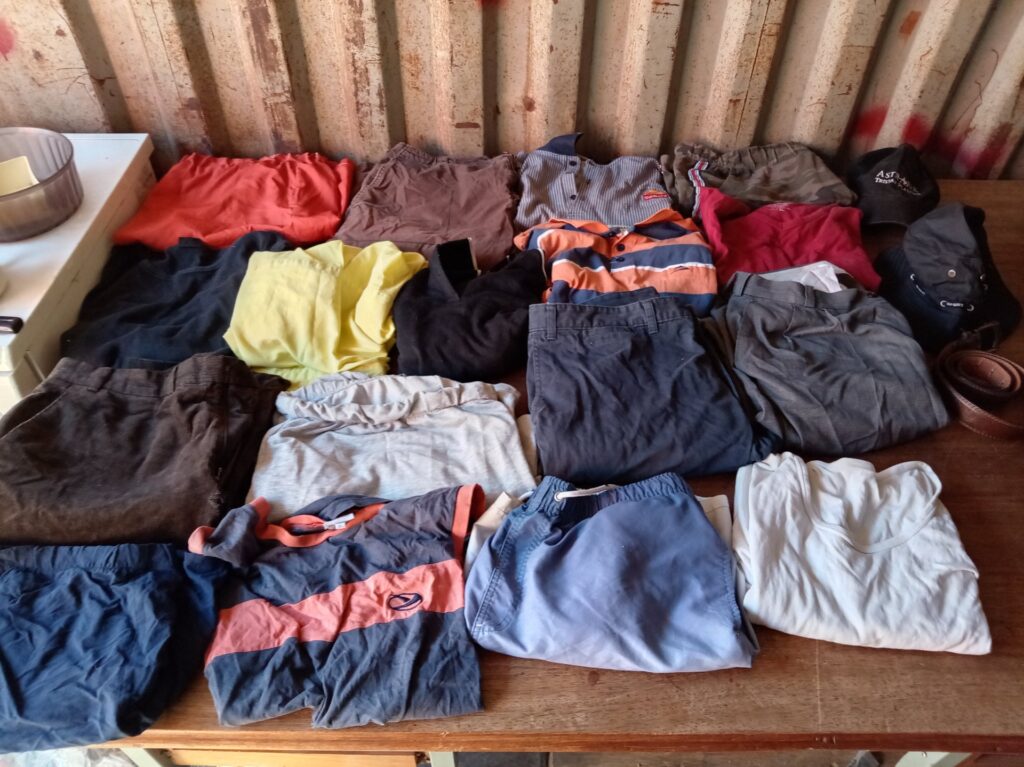 Joblot: Mixed men’s clothing & accessories — shirts, shorts, trousers, caps + leather belt (used)