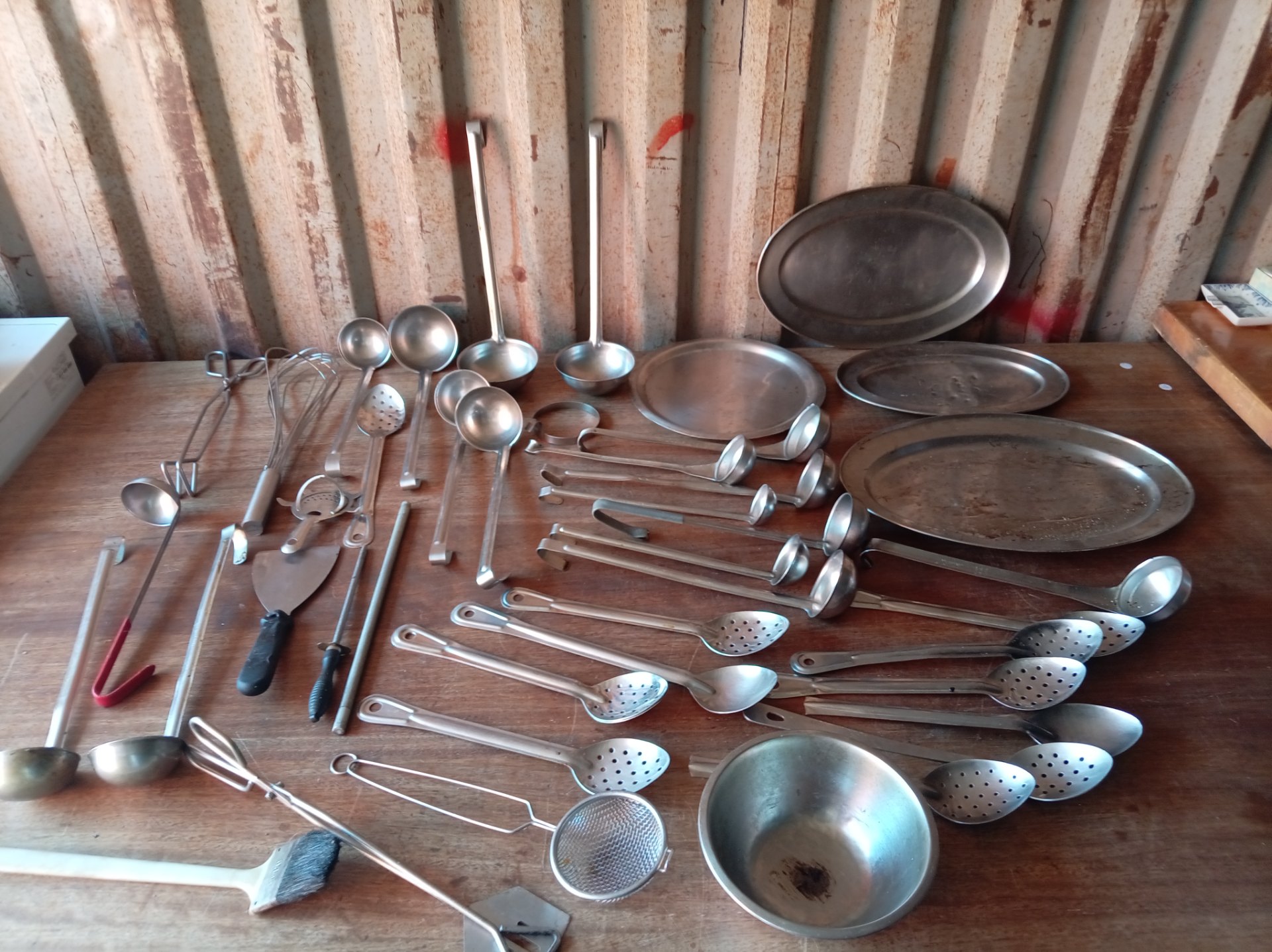 Bulk lot of stainless-steel kitchen utensils & serving platters — assorted ladles, skimmers, tongs, whisks (used)