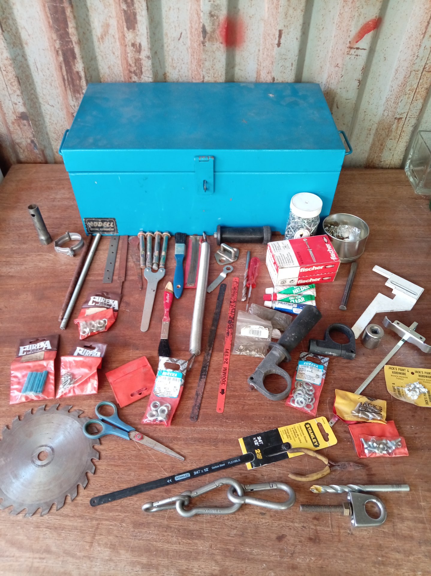 Blue Audell metal toolbox packed with mixed hardware — fixings, small tools & packaged Eureka/Fischer items