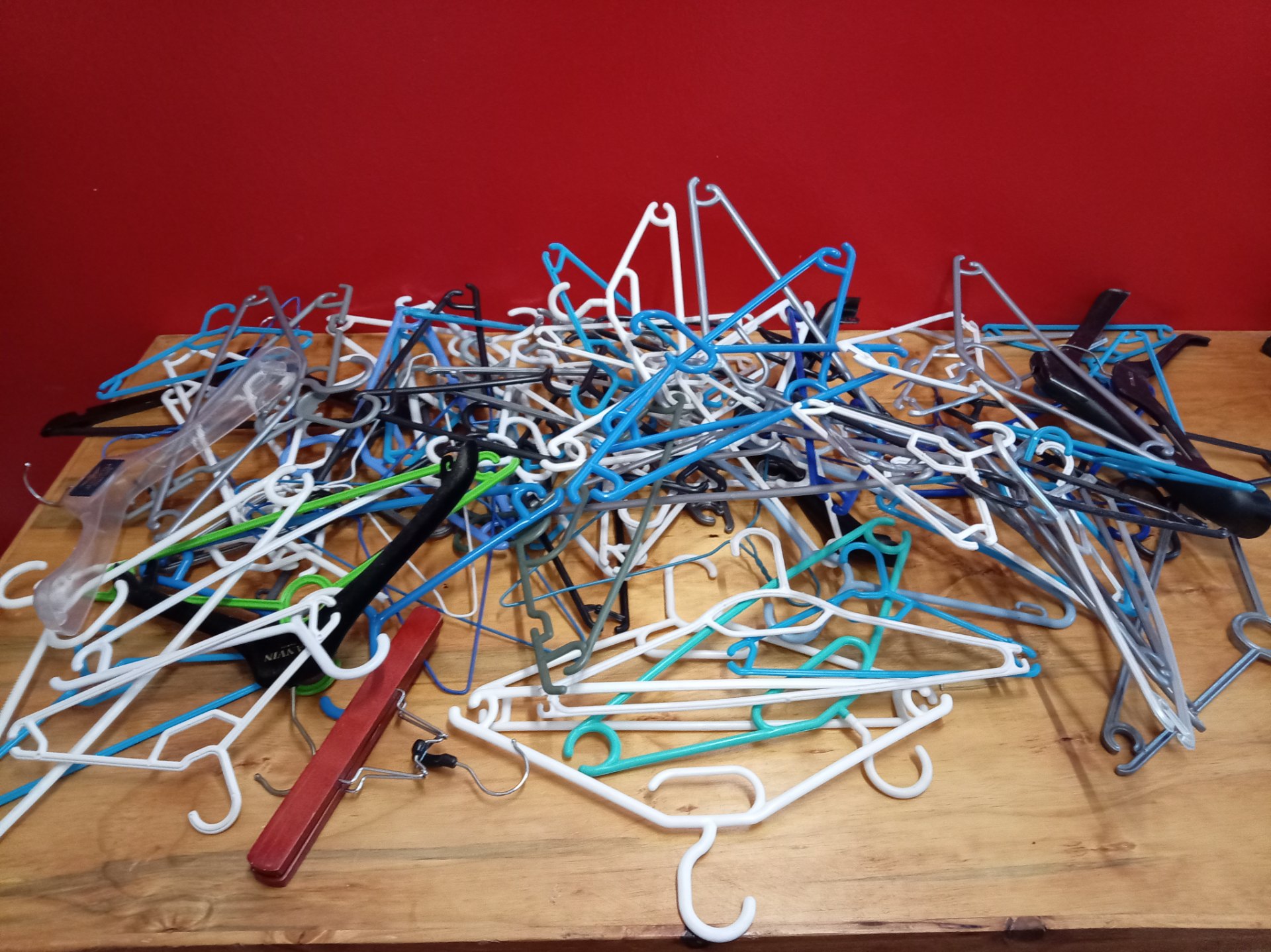 Mixed used clothing hangers — assorted plastic & metal pile (table full)