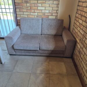 Two‑seater woven fabric sofa / seller describes as brown sleepcouch — used, stained, fabric pulls