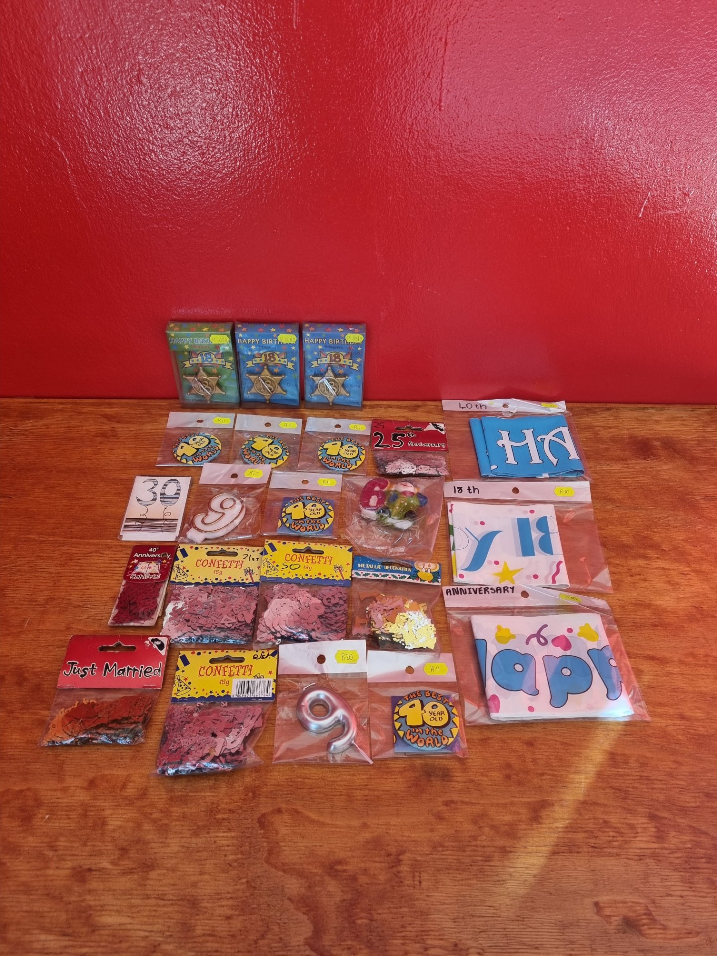 Mixed lot of new party supplies — badges, confetti, banners, number candles, novelty magnets (sealed packs)