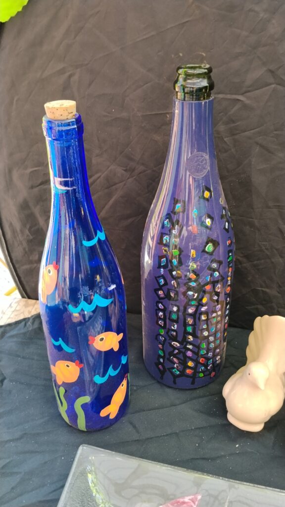 Mixed decorative homeware lot — painted glass bottles, fused-glass fish platter, ceramic birds & large red column vase (cracked)