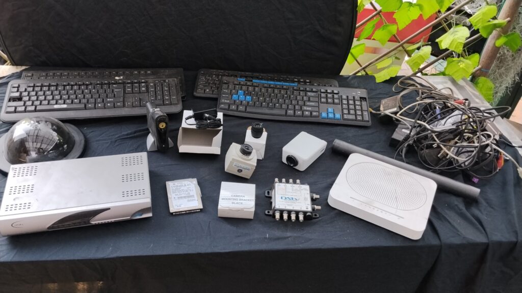 Mixed electronics bulk lot — CCTV cameras & lenses, Hitachi 320GB HDD, DSTV receiver + multiswitch, keyboards, router, speaker, cables & adapters (untested)
